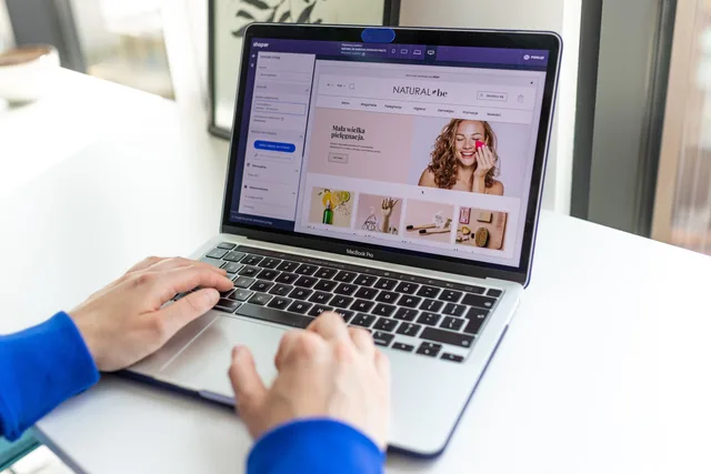 Hands typing on a laptop with an e-commerce website open, showcasing online shopping. Virksomhedsformer for en dansk webshop